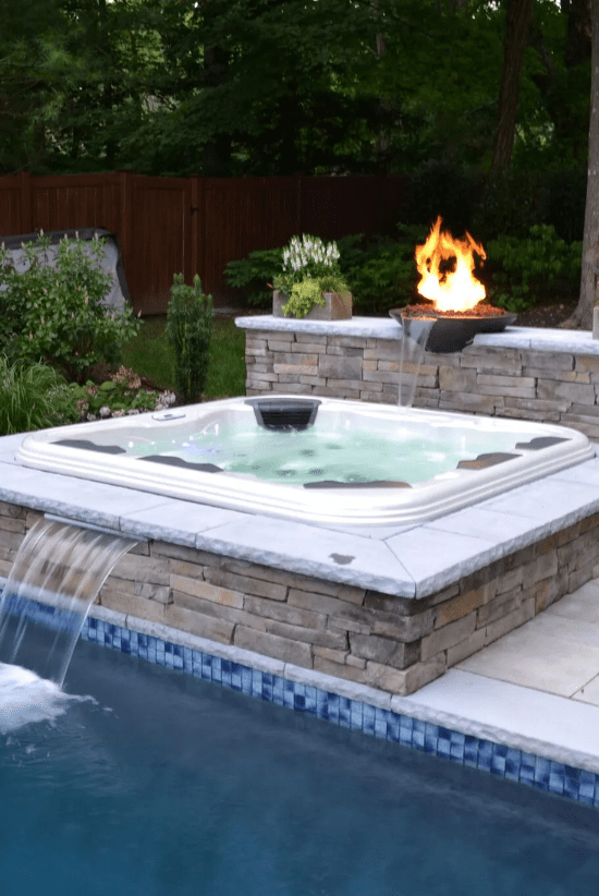 hot tub with a backyard pool